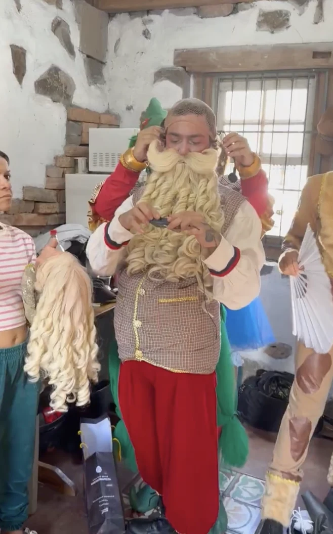 Detalhe de figurino: Papai Noel ajustando a barba nos bastidores